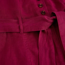 Load image into Gallery viewer, Close-up of a magenta jumpsuit with buttons and a belt
