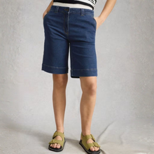 Load image into Gallery viewer, Person wearing blue denim shorts on a plain background
