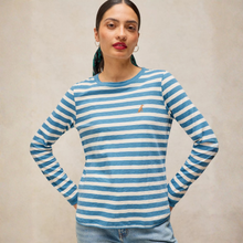 Load image into Gallery viewer, A woman modeling a long-sleeve crewneck top with horizontal blue and white stripes, featuring a small embroidered polo player logo on the left chest, set against a neutral beige background.
