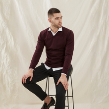 Load image into Gallery viewer, Man sitting on a stool wearing a burgundy sweater over a white shirt with black pants against a neutral background
