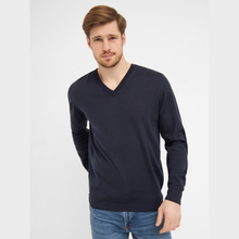 Load image into Gallery viewer, Man wearing a navy V-neck sweater and blue jeans on a white background
