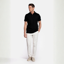 Load image into Gallery viewer, Man wearing a black polo shirt and white pants on a white background
