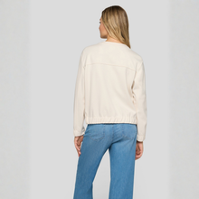 Load image into Gallery viewer, Woman wearing a cream blouse and blue jeans on a plain background
