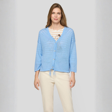 Load image into Gallery viewer, Woman wearing a light blue cardigan over a striped shirt on a plain background
