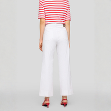 Load image into Gallery viewer, Person wearing a red and white striped shirt with white wide-leg pants on a light gray background
