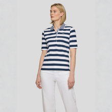 Load image into Gallery viewer, Woman wearing a navy and white striped polo shirt with a logo on a light gray background
