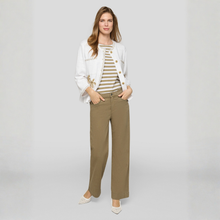 Load image into Gallery viewer, Woman wearing a white jacket, striped shirt, and brown pants on a gray background
