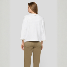 Load image into Gallery viewer, Woman wearing a white blouse with lace trim and brown pants on a light gray background
