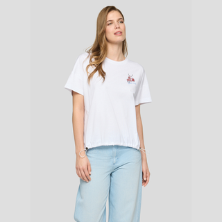 Woman wearing a white t-shirt with a small logo and light blue jeans on a plain background