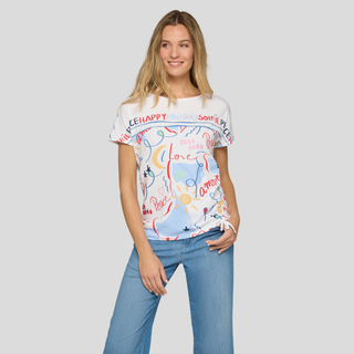 Woman wearing a white t-shirt with colorful text and graphics on a plain background