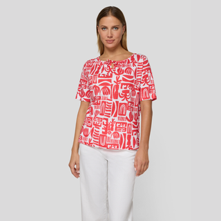 Red & White print top on lady with white trousers 