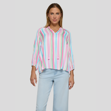 Load image into Gallery viewer, Woman wearing a colorful striped shirt and light blue jeans on a plain background
