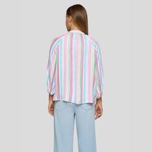 Load image into Gallery viewer, Person wearing a colorful striped shirt and light blue jeans on a plain background
