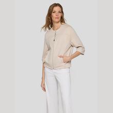 Load image into Gallery viewer, Woman wearing a beige jacket and white pants on a plain background
