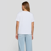 Load image into Gallery viewer, Person wearing a white t-shirt and light blue jeans on a plain background
