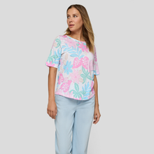 Load image into Gallery viewer, Woman wearing a pastel floral top and light blue pants on a plain background
