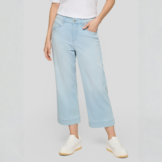 Light blue jeans worn by a person on a plain background
