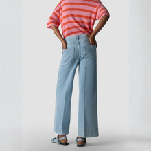 Load image into Gallery viewer, Person wearing a pink and orange striped shirt and light blue jeans on a plain background
