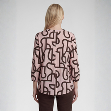 Load image into Gallery viewer, A woman viewed from the back wearing a light pink blouse with a dark brown abstract line pattern and dark brown pants, set against a plain light gray studio background.
