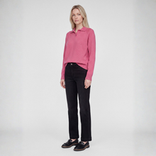 Load image into Gallery viewer, A woman modeling a pink long-sleeve polo shirt with black trousers and black loafers, standing against a light gray studio background.
