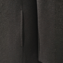 Load image into Gallery viewer, Close-up detail of a dark charcoal gray wool coat showing the texture of the fabric and a vertical seam.
