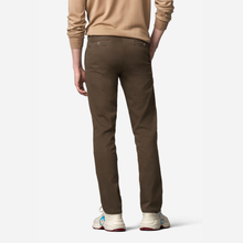 Load image into Gallery viewer, A person shown from the back wearing slim-fit brown trousers, a beige long-sleeve top, and white sneakers against a clean white studio background.

