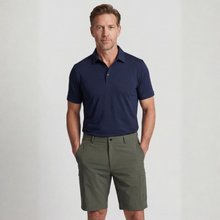 Load image into Gallery viewer, Man wearing a navy polo shirt and green shorts on a light gray background
