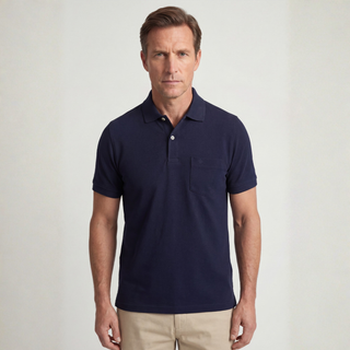 Man wearing a navy polo shirt against a plain background