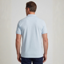 Load image into Gallery viewer, Man wearing a light blue polo shirt against a plain background
