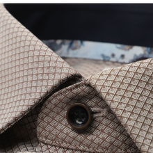 Load image into Gallery viewer, Close-up of a patterned collared shirt or jacket fabric with a geometric woven design in beige and brown, featuring a dark brown button.
