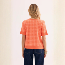Load image into Gallery viewer, Person wearing an orange checkered shirt and blue jeans on a plain background
