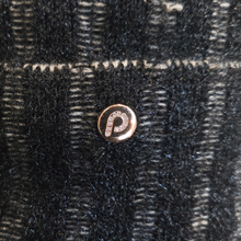 Load image into Gallery viewer, A close-up of a small round rose gold button with a letter 'P' set with clear rhinestones, resting on a black and gray plaid knit fabric.
