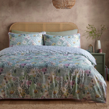 Load image into Gallery viewer, Floral bedding set on a bed with a wicker headboard in a bedroom setting.
