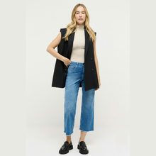 Load image into Gallery viewer, Woman wearing a black vest, beige top, blue jeans, and black shoes on a white background
