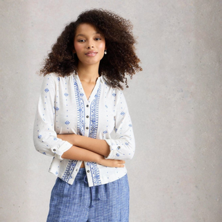 Mid view of model wearing White Stuff Annie Jersey Shirt, White Print, with a light grey background.