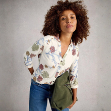 Load image into Gallery viewer, Woman wearing a patterned shirt and holding a green bag against a gray background
