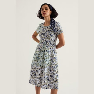 woman in dress with floral print on light background 