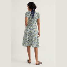 Load image into Gallery viewer, Woman wearing a floral dress on a plain background
