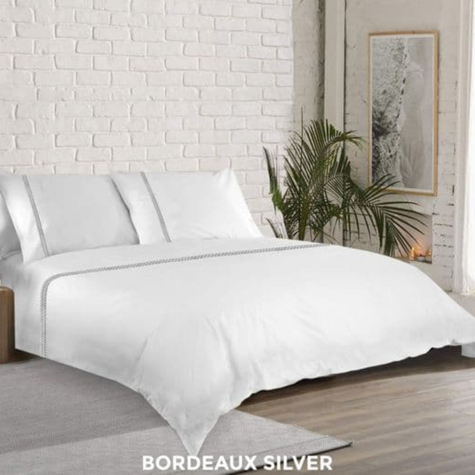 Duvet cover and pillowcase displayed on bed and in a bedroom setting 