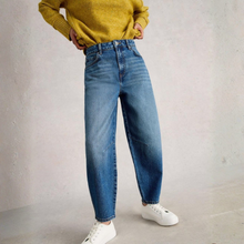 Load image into Gallery viewer, Half view of Model wearing White Stuff Aubrey Barrel Leg Jean, in Light denim, with a grey background.

