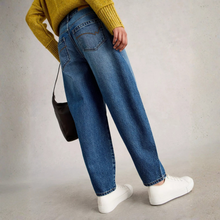 Load image into Gallery viewer, Person wearing blue jeans and a yellow sweater with a black bag on a plain background
