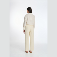 Load image into Gallery viewer, Person wearing a white shirt and beige pants on a white background
