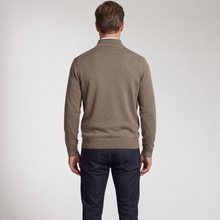 Load image into Gallery viewer, A man viewed from behind wearing a taupe brown knit sweater and dark blue jeans, standing against a light gray studio background.
