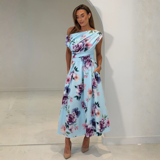 Woman wearing a floral off-shoulder dress against a plain background
