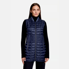Load image into Gallery viewer, A woman modeling a navy blue quilted puffer vest over a black long-sleeve top, photographed against a plain light gray studio background.
