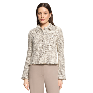 A woman modeling a cropped, long-sleeve tweed jacket in a beige and black marled pattern, paired with beige trousers, against a plain white background.