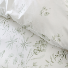 Load image into Gallery viewer, Floral-patterned fabric with a pillow on a light background
