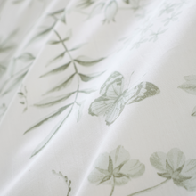 Load image into Gallery viewer, Close-up of a fabric with green floral patterns on a white background
