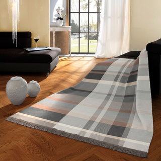 Plaid blanket on a wooden floor in a living room setting