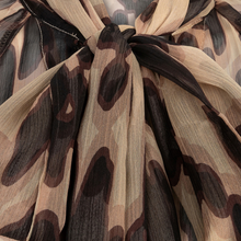 Load image into Gallery viewer, A close-up of a lightweight sheer fabric with an abstract leopard-like pattern in beige, brown, and black, gathered and tied at the top.
